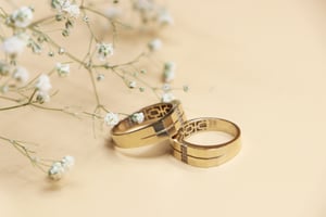 Wedding rings next to white flowers