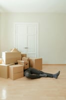 Man struggling with cluttered boxes, highlighting the convenience of using U Can Store for personal storage needs.