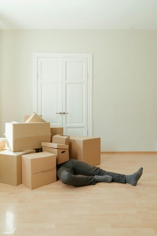 Man struggling with cluttered boxes, highlighting the convenience of using U Can Store for personal storage needs.